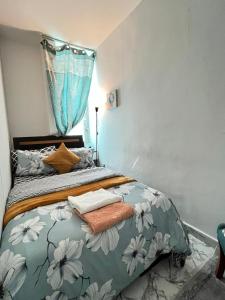 Schlafzimmer mit einem Bett mit einer blauen und weißen Bettdecke in der Unterkunft Tanih Place in Abu Dhabi