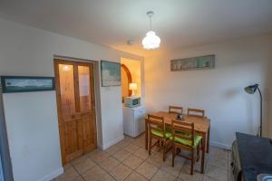 una sala da pranzo con tavolo, sedie e forno a microonde di Waterfall Cottage a Carnlough Altre 5 foto