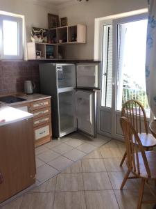 a kitchen with a refrigerator and a table and chairs at Apartment Nelli in Herceg-Novi