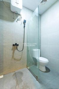 a bathroom with a toilet and a glass shower stall at Destiny House in Yogyakarta