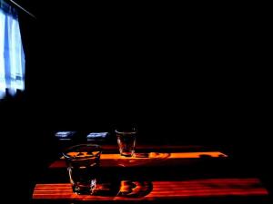 two glasses sitting on a wooden table in a dark room at usj-難波-道頓堀-大阪駅-海遊館-大阪城-関西空港-奈良へ直通 in Osaka