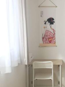 大阪的住宿－usj-難波-道頓堀-大阪駅-海遊館-大阪城-関西空港-奈良へ直通，一张桌子和一把椅子,放在一个有女人照片的房间