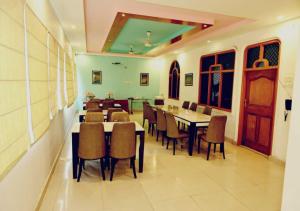 Hotel Varuna Inn في فاراناسي: غرفة طعام مع طاولات وكراسي في غرفة