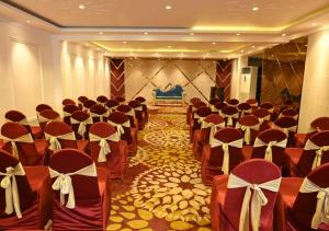una fila di sedie in una sala banchetti con archi di Hotel Varuna Inn a Varanasi