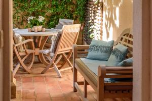 a patio with chairs and a table and a table and chairs at Maison Magdeleine in Saint-Tropez