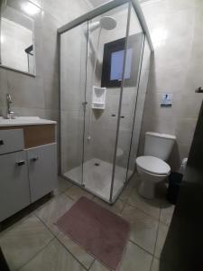 ein Bad mit einer Dusche, einem WC und einem Waschbecken in der Unterkunft Casa da Cris/Marcelo in Gramado