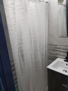 a bathroom with a shower curtain and a sink at Apartments for short stay in Ashalebotwe