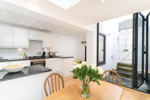 une cuisine avec une table avec un vase de fleurs dessus dans l'établissement Beautiful and Contemporary Cornish townhouse in Penzance, à Penzance