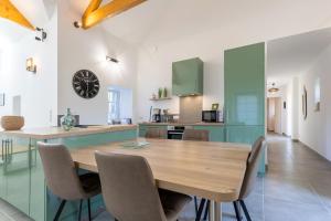 a kitchen and dining room with a wooden table and chairs at Gite plain-pied - 4 personnes in Landrévarzec