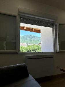 a window in a room with a view of a mountain at Studio rénové centre-ville de Lagnieu / WIFI in Lagnieu