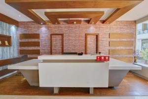 a large white reception desk in a room with a brick wall at Ooty Residency in Ooty