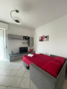 una camera con letto rosso e TV a schermo piatto di Appartamento Stelvio a Novate Milanese