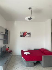 Camera bianca con letto rosso e lampada di Appartamento Stelvio a Novate Milanese