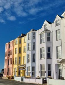 uma fila de edifícios de apartamentos coloridos em Glan y Mor, Sleeps 20, 8 Bedrooms, 8 Bathrooms, Seafront, Criccieth em Criccieth