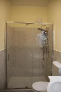 W łazience znajduje się prysznic ze szklanymi drzwiami. w obiekcie Sole Nascente Apartment w mieście Giardini Naxos