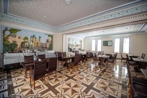 a banquet hall with tables and chairs in a room at Reikartz Modarixon Bukhara in Bukhara