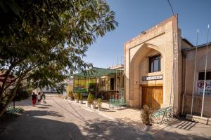 an empty street in a town with a building at Reikartz Modarixon Bukhara in Bukhara