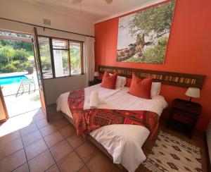 a bedroom with a bed and a painting of a giraffe at Marula Lodge in Swellendam