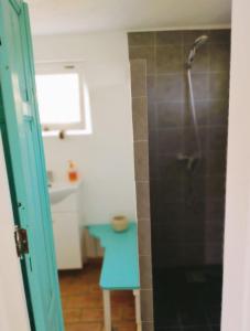 La salle de bains est pourvue d'une douche avec un tabouret bleu. dans l'établissement Casa Papoula, à São Brás de Alportel