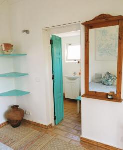 La salle de bains est pourvue d'un miroir et d'un lavabo. dans l'établissement Casa Papoula, à São Brás de Alportel