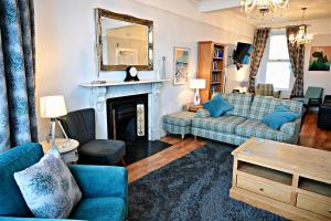un soggiorno con divano e camino di Glan y Mor, Sleeps 20, 8 Bedrooms, 8 Bathrooms, Seafront, Criccieth a Criccieth