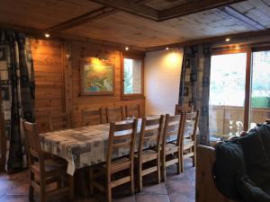 a dining room with a table and wooden walls at Les Dolomites in La Plagne Tarentaise