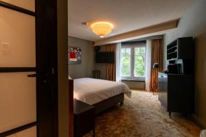 una camera d'albergo con letto e finestra di Hotel Mai Amsterdam ad Amsterdam