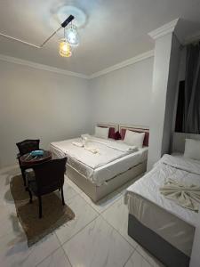 una camera da letto con due letti, un tavolo e delle sedie di Ahmose Pyramids view inn a Il Cairo