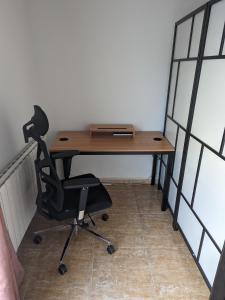 a desk with a chair in a room with windows at Vivienda compartida con ambiente familiar in Seseña