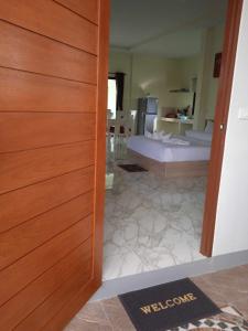 a door leading into a room with a bedroom at M&N Guesthouse Kata in Kata Beach