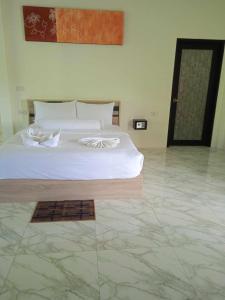 a bedroom with a white bed and a tile floor at M&N Guesthouse Kata in Kata Beach