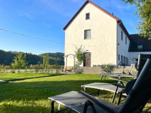 a group of picnic tables in front of a building at Ferienhaus Backesgarten für 22 Personen in Neichen