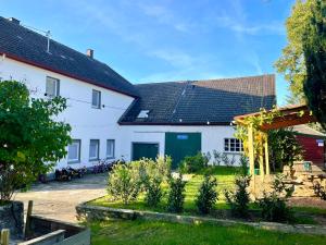 a white house with solar panels on the roof at Ferienhaus Backesgarten für 22 Personen in Neichen