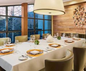 a dining room with a large white table and chairs at Grand Hyatt Vail Hotel Room With King Bed in Vail
