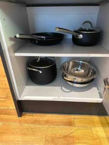 a shelf with pots and pans and a bowl at 1 BR in St James Piccadilly HY10 in London
