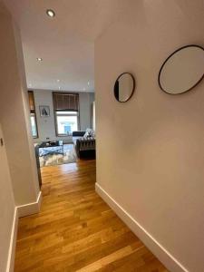 a living room with two mirrors on a wall at 1 BR in St James Piccadilly HY10 in London