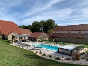 uma piscina com espreguiçadeiras ao lado de uma casa em Chez Clément em Balesmes-sur-Marne