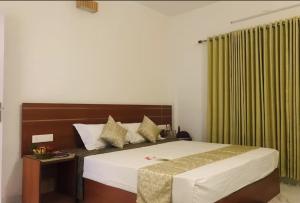 a bedroom with a large bed and a green curtain at Shiv Dwelling - Full Villa in Ujjain