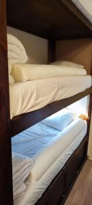 two bunk beds with white sheets and pillows on them at Sunny Snow Studio les Orres 1650 in Les Orres