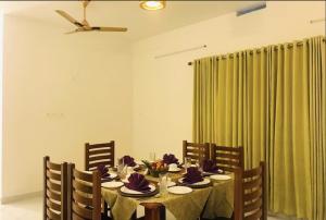 a dining room with a table with purple flowers on it at Shiv Dwelling - Full Villa in Ujjain