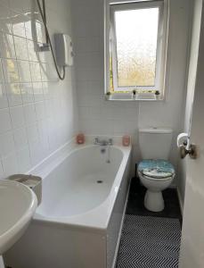 uma casa de banho branca com uma banheira e um WC em Largs Top Floor Flat em Largs