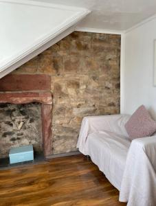 um quarto com uma parede de pedra e uma cama em Largs Top Floor Flat em Largs