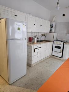 a kitchen with white cabinets and a white refrigerator at Lo de Leo in Salta