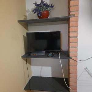 a television sitting on a shelf in a room at Pousada Morada dos Pássaros in Peruíbe