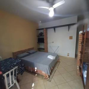 a bedroom with a bed and a ceiling fan at Pousada Morada dos Pássaros in Peruíbe +5 photos