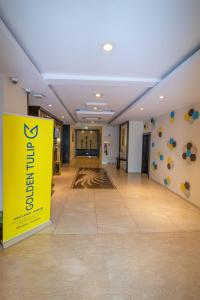 a large hallway with a yellow sign in a building at Golden Tulip Westlands Nairobi in Nairobi
