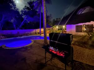 a fire pit next to a swimming pool at night at Kongo Dream in Diani Beach