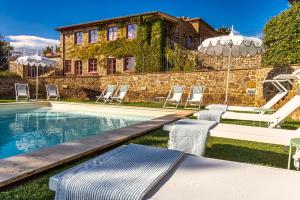 Casa con piscina con sillas y sombrilla en Le Ragnaie, en Montalcino