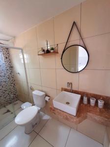 a bathroom with a toilet and a sink and a mirror at Apê Serrano in Serra de São Bento