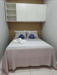 Una cama con armarios blancos y dos toallas. en Apê Serrano en Serra de São Bento